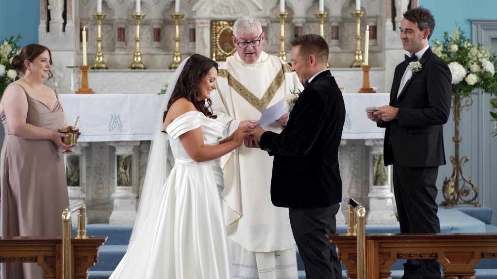 Gemma placing a wedding ring on Josh's finger during their ceremony at St Mary’s Church, Ballybrack.