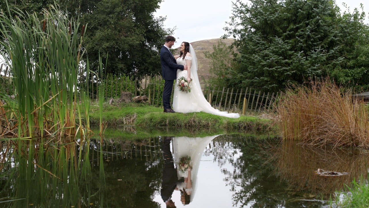Bride and groom reflected in a pond at a the Rocky Mountain Cottage.