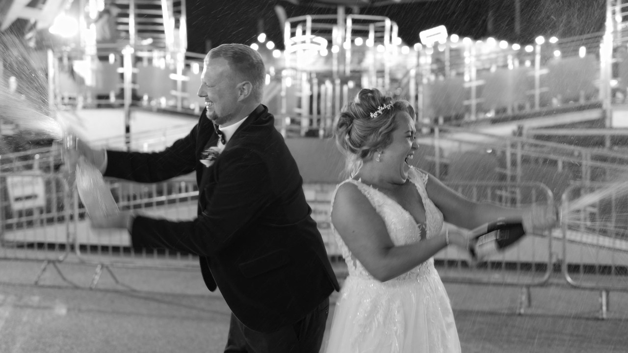 Bride and groom popping champagne at Derry Halloween Carnival fairground.
