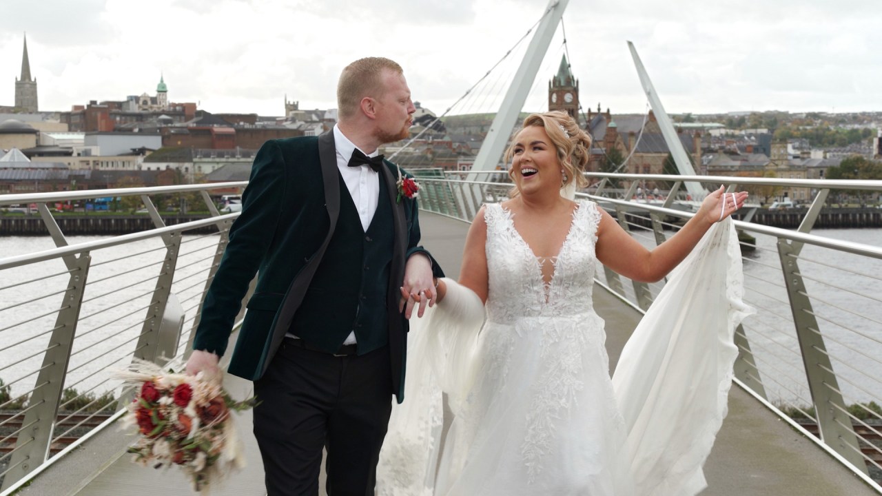 Newlyweds Sheree and Jonathan walking across the Peace Bridge in Derry.
