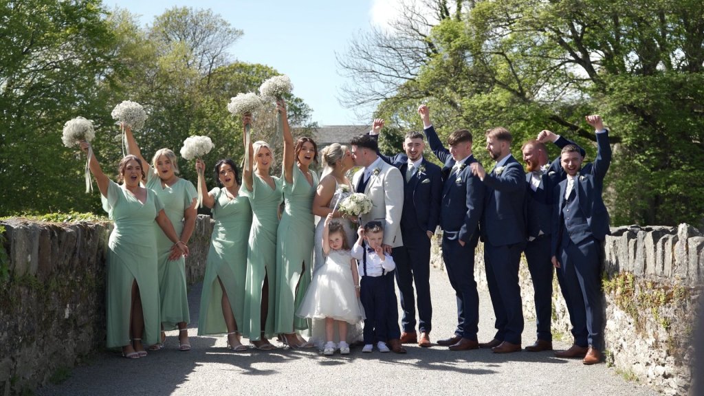 Ciara and Darian's wedding party posing on the stone bridge at Swan Park Buncrana Donegal.
