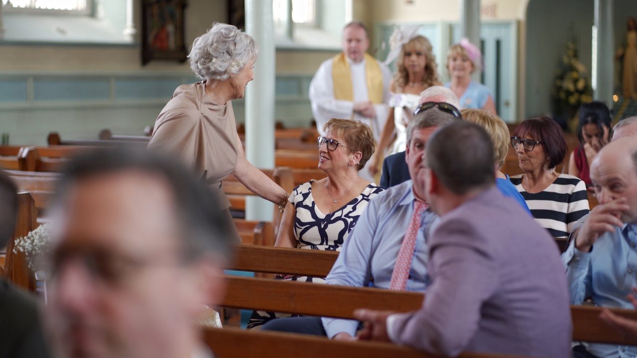 Wedding guests chatting in the pews of St Mary's Church Cockhill before the ceremony.