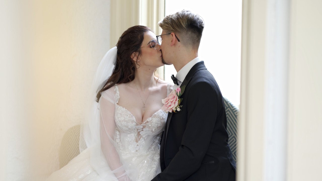 Close-up of bride Carolann and groom Jack sharing a kiss by a window at Beech Hill Country House.