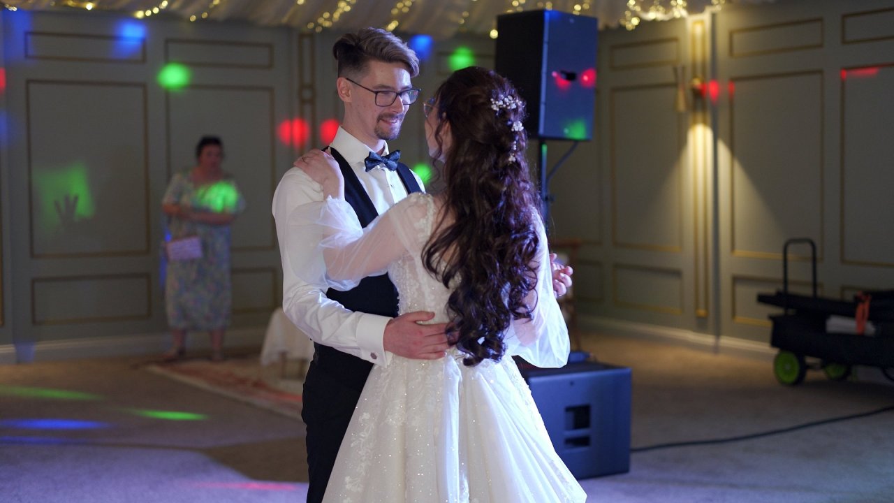 Carolann and Jack dancing their first dance under coloured lights at their Beech Hill wedding reception.