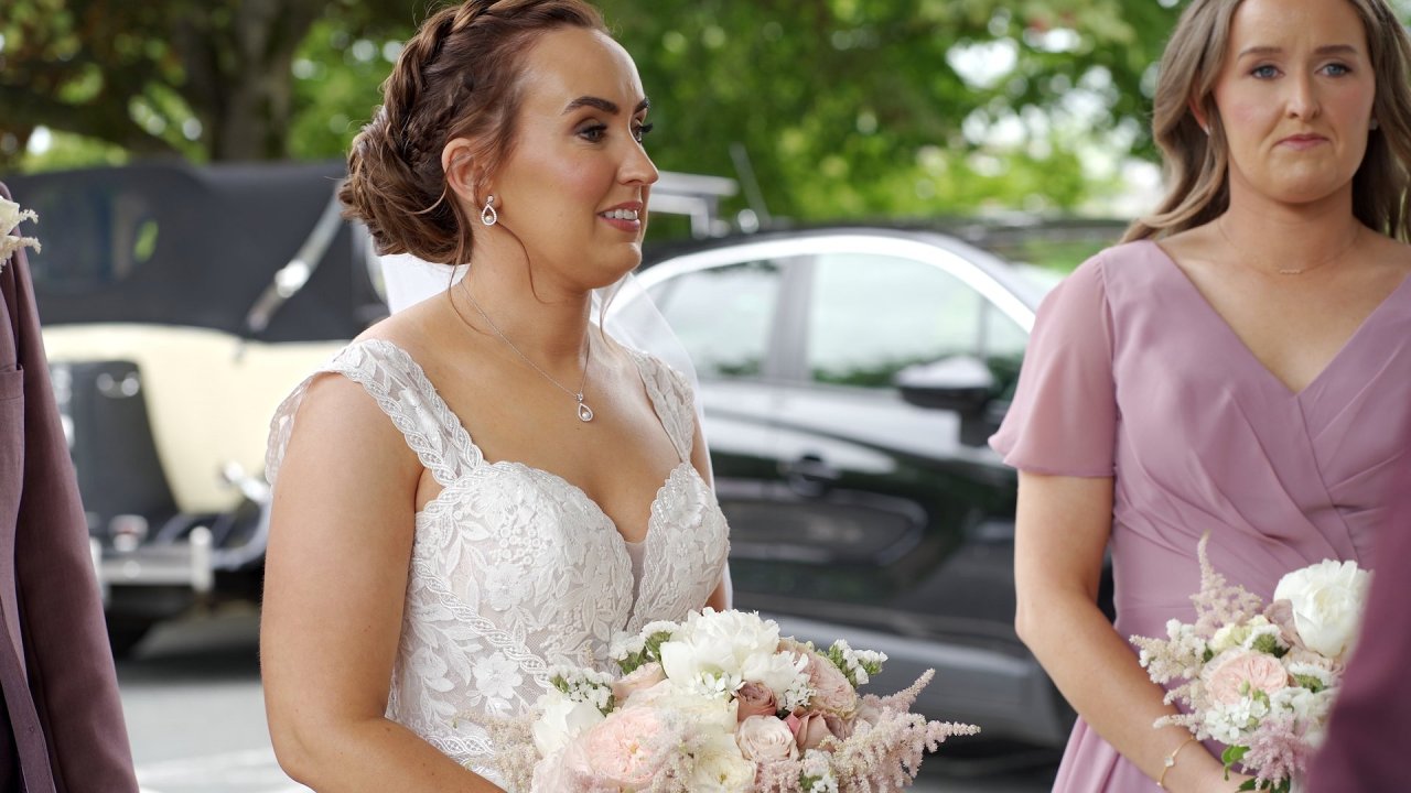 Close up of bride Carol-Ann holding her bouquet with bridesmaid at St Brigid’s Church.