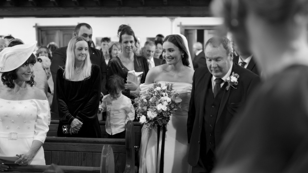 Black and white candid of Claire smiling at her mum during her wedding ceremony in Ballymena.
