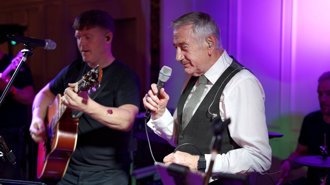 Live band and country singer Eamon McCann performing at a wedding reception with purple stage lighting.
