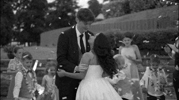 Black and white video of a bride and groom embracing as children throw confetti at Lusty Beg Resort.