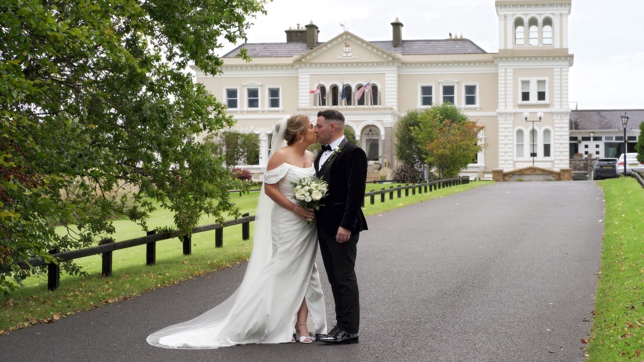 Cora and Conor kissing on the driveway in front of the historic Manor House Country Hotel in Enniskillen.