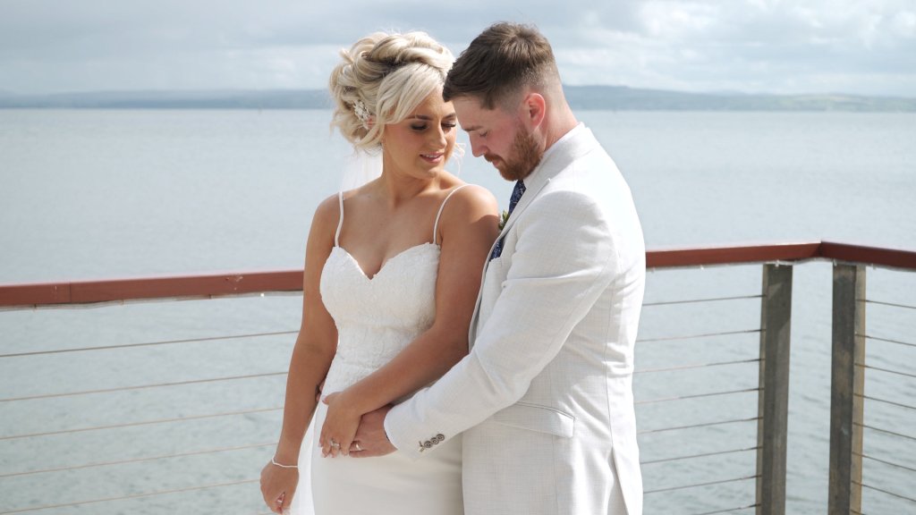 Rikita and Jordan posing by the water at Redcastle Hotel wedding in Donegal.