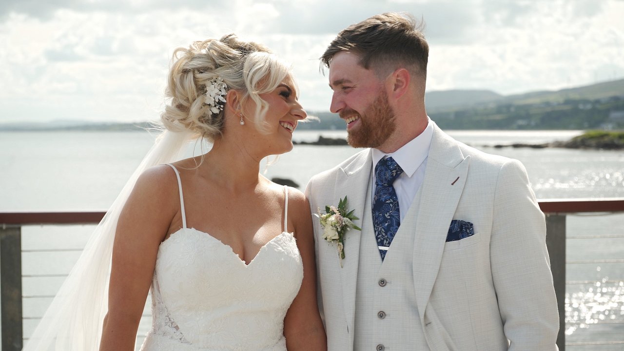 Bride Rikita and groom Jordan smiling at each other during their summer wedding at Redcastle Hotel.