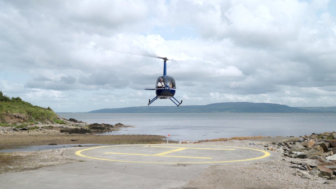 A blue helicopter landing on the helipad at Redcastle Hotel for a wedding.