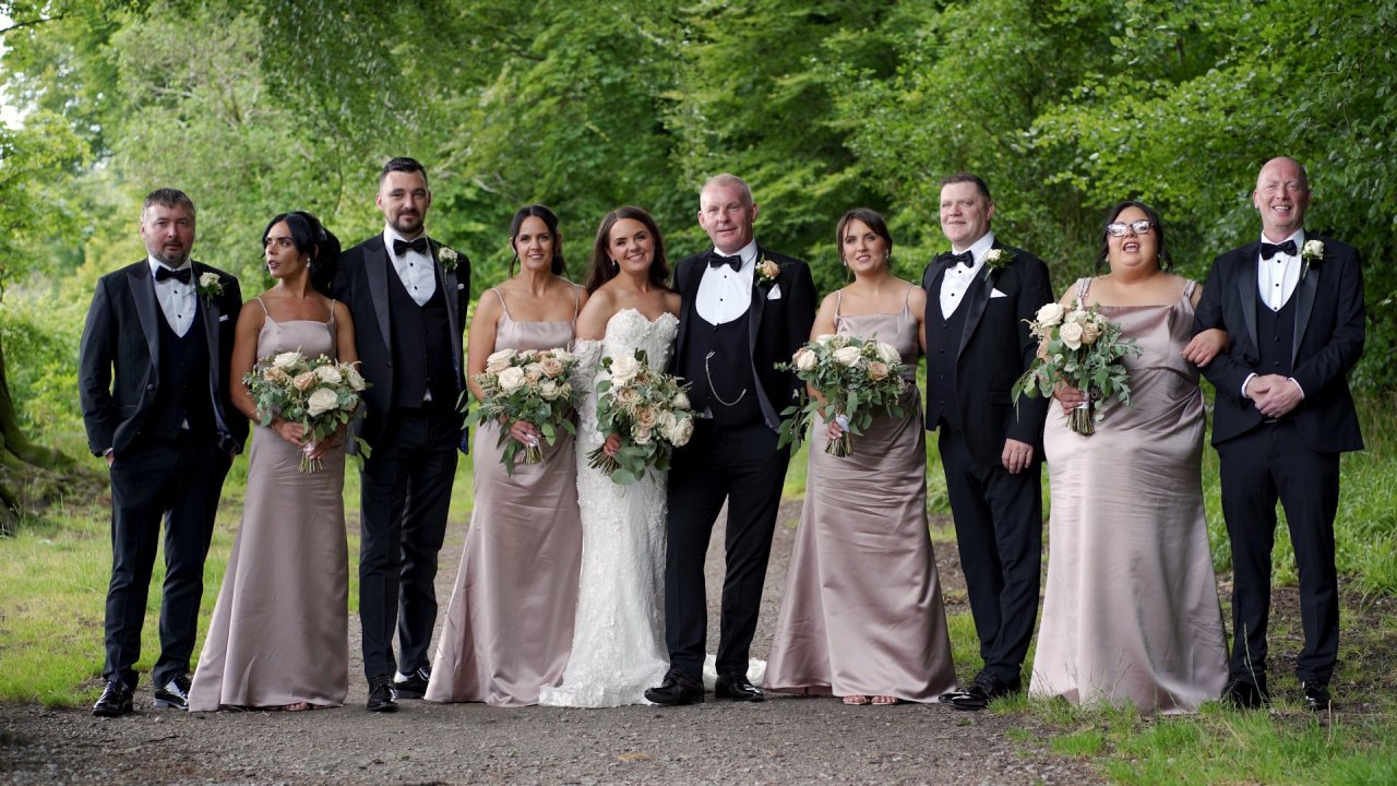 Roisin and Dermot with their bridesmaids in champagne dresses and groomsmen in tuxedos at Drumboe Woods.