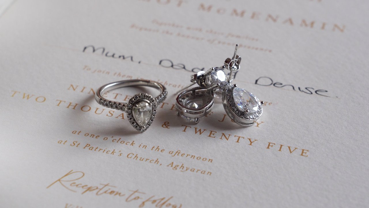 Pear-shaped diamond engagement ring and earrings on a St Patrick's Church, Aghyaran wedding invitation.