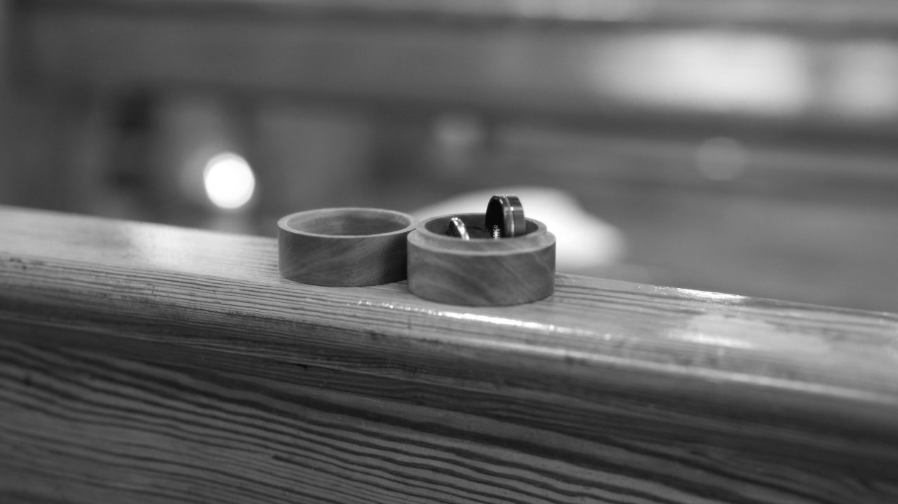 Close-up of wedding rings in a wooden box on a church pew at St Mary's Chapel.