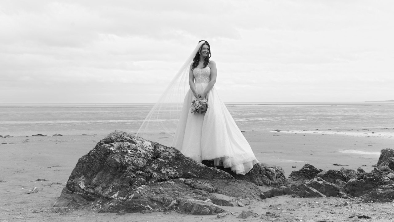 Black and white solo portrait of bride Kelly at Priest's Beach Blackrock.