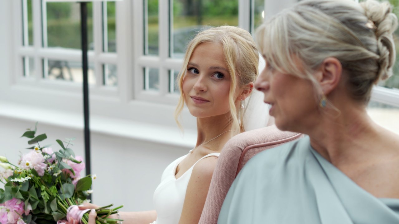 Candid shot of bride Hannah sitting at Tullyglass Hotel reception.