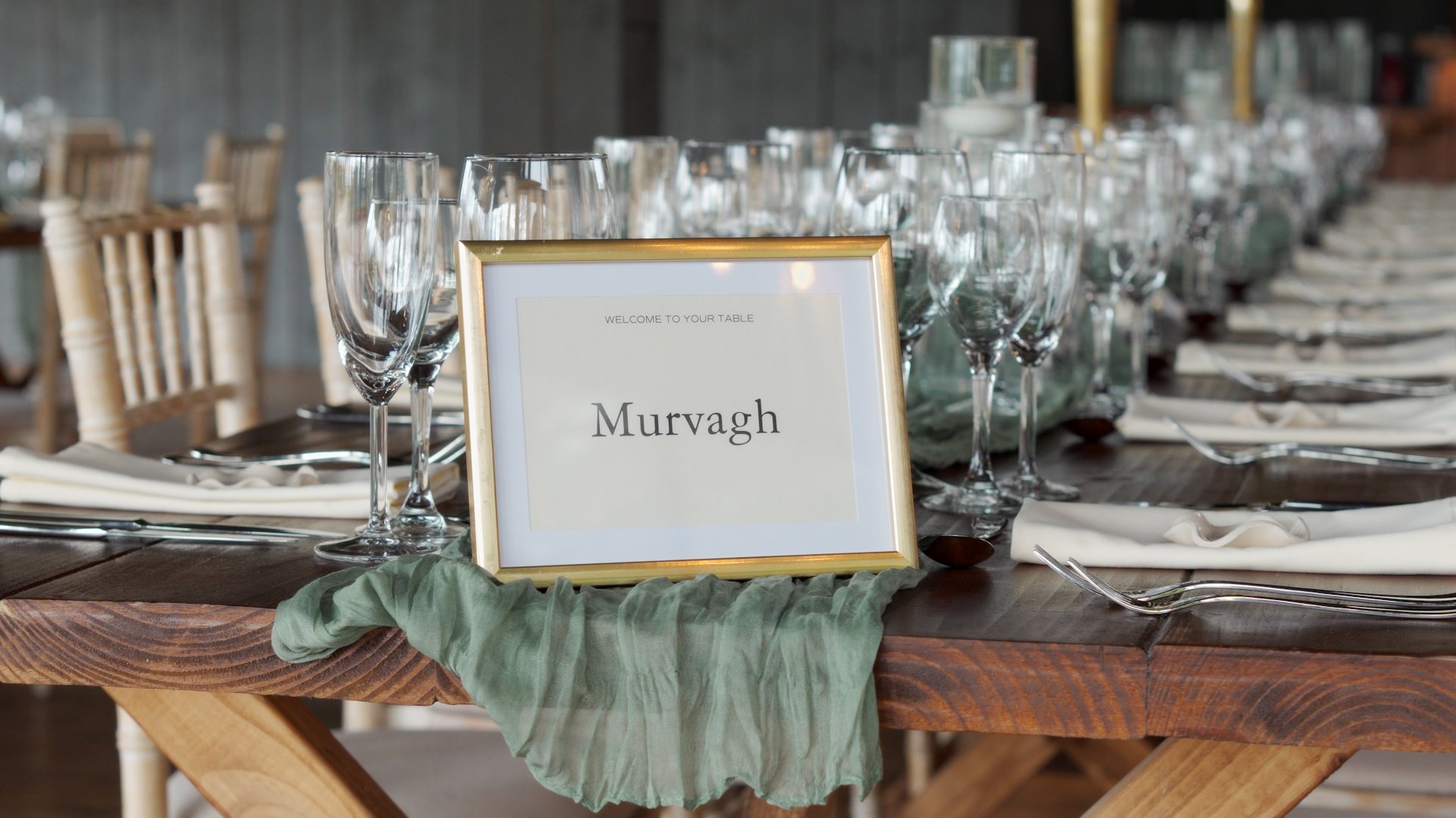 Murvagh wedding table name sign in a gold frame with sage green runner at Ballyness Resort reception.