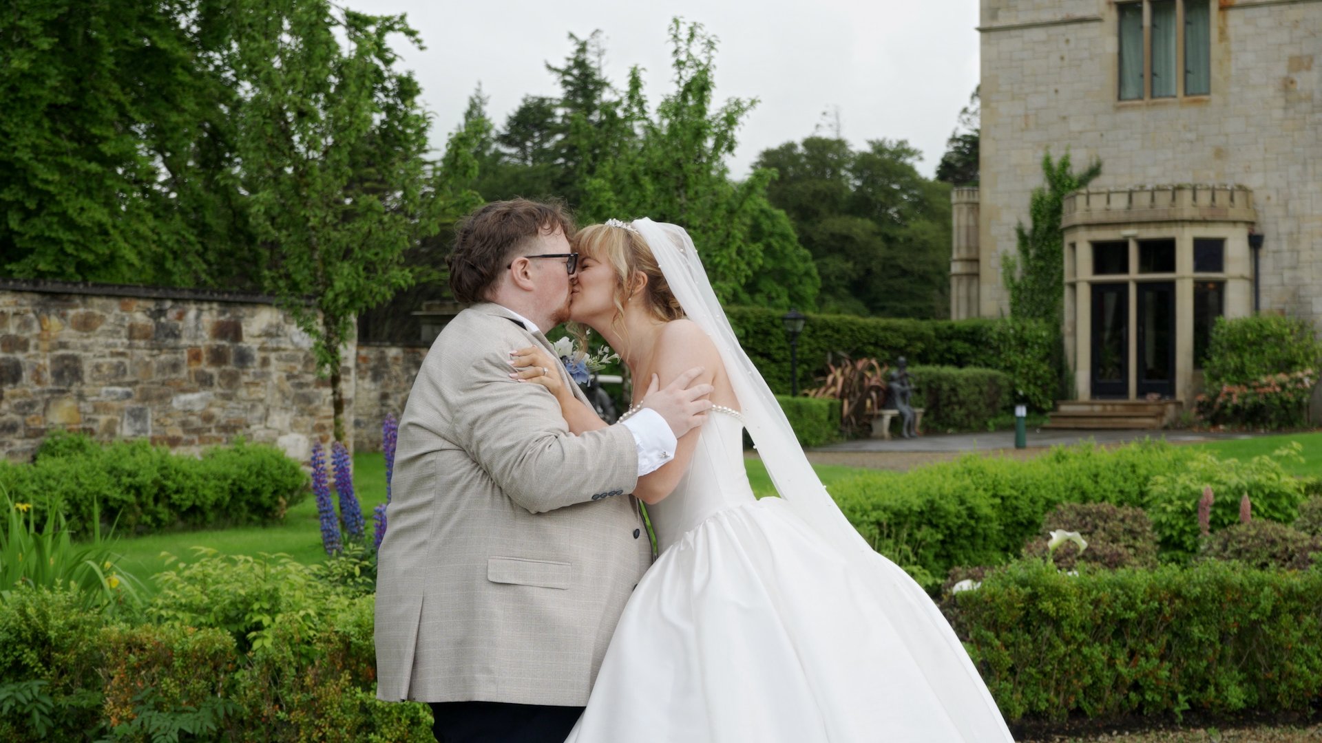 Samantha and Aaron sharing a romantic kiss in the castle gardens during their Lough Eske wedding.