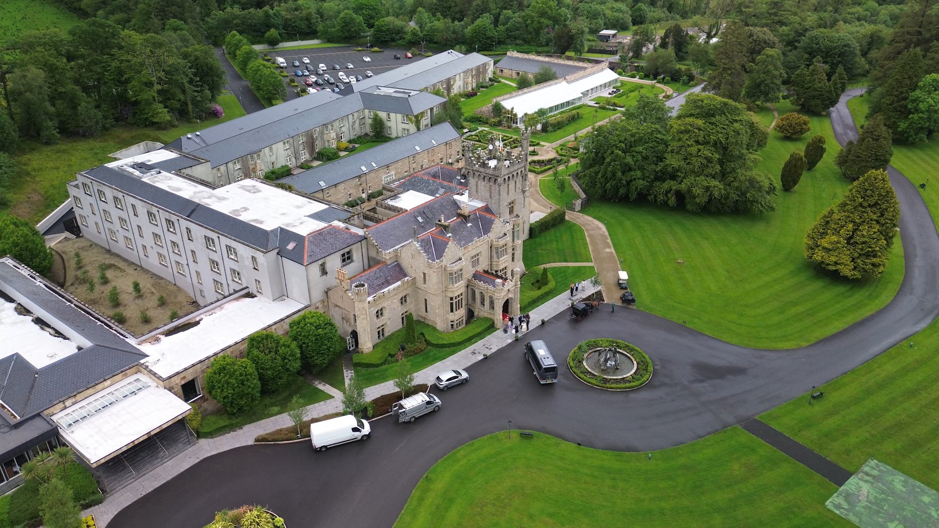 Drone view of Lough Eske Castle courtyard showing arriving wedding guests and cars.