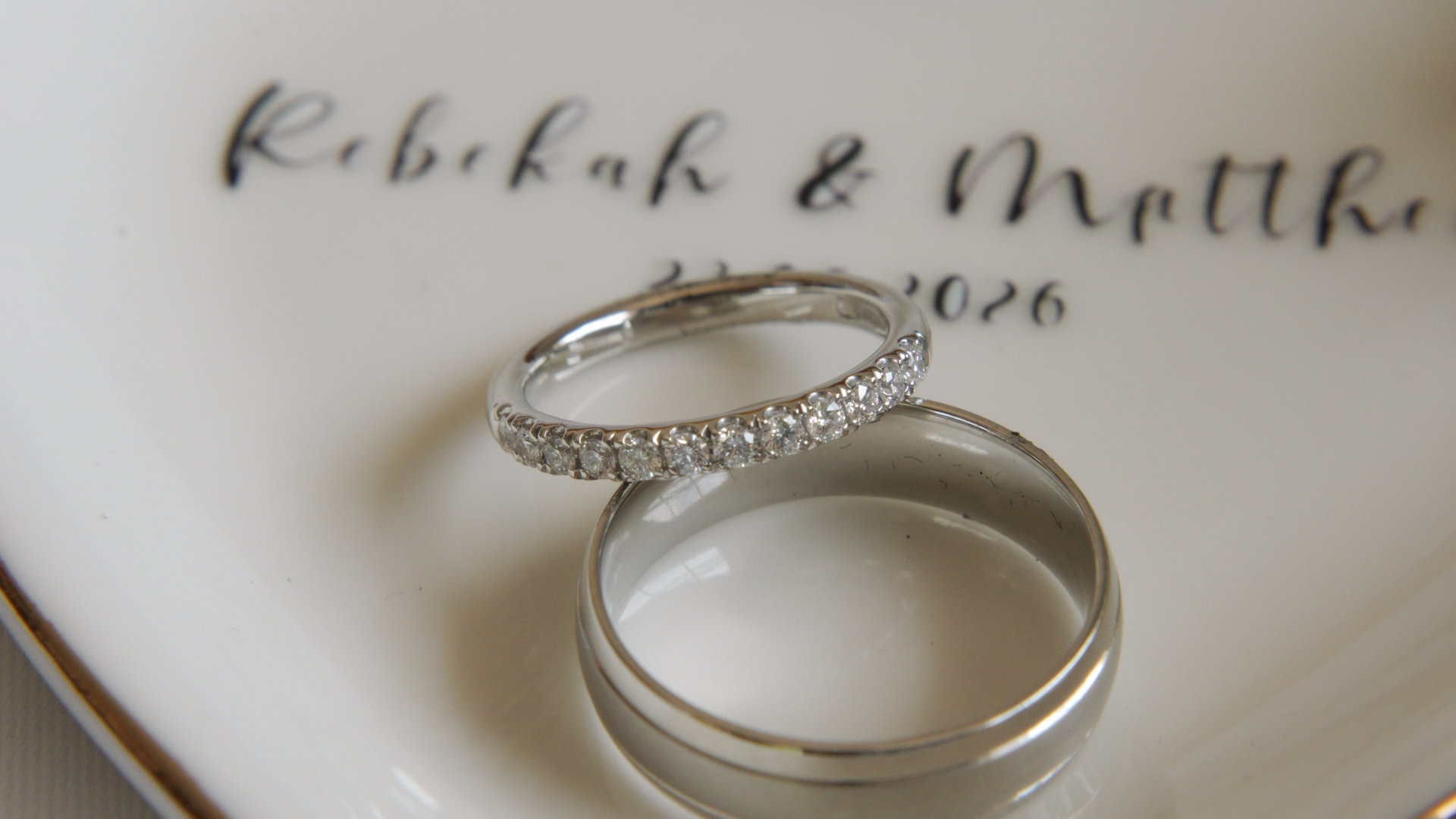 Macro shot of the couple's wedding bands on a porcelain dish.
