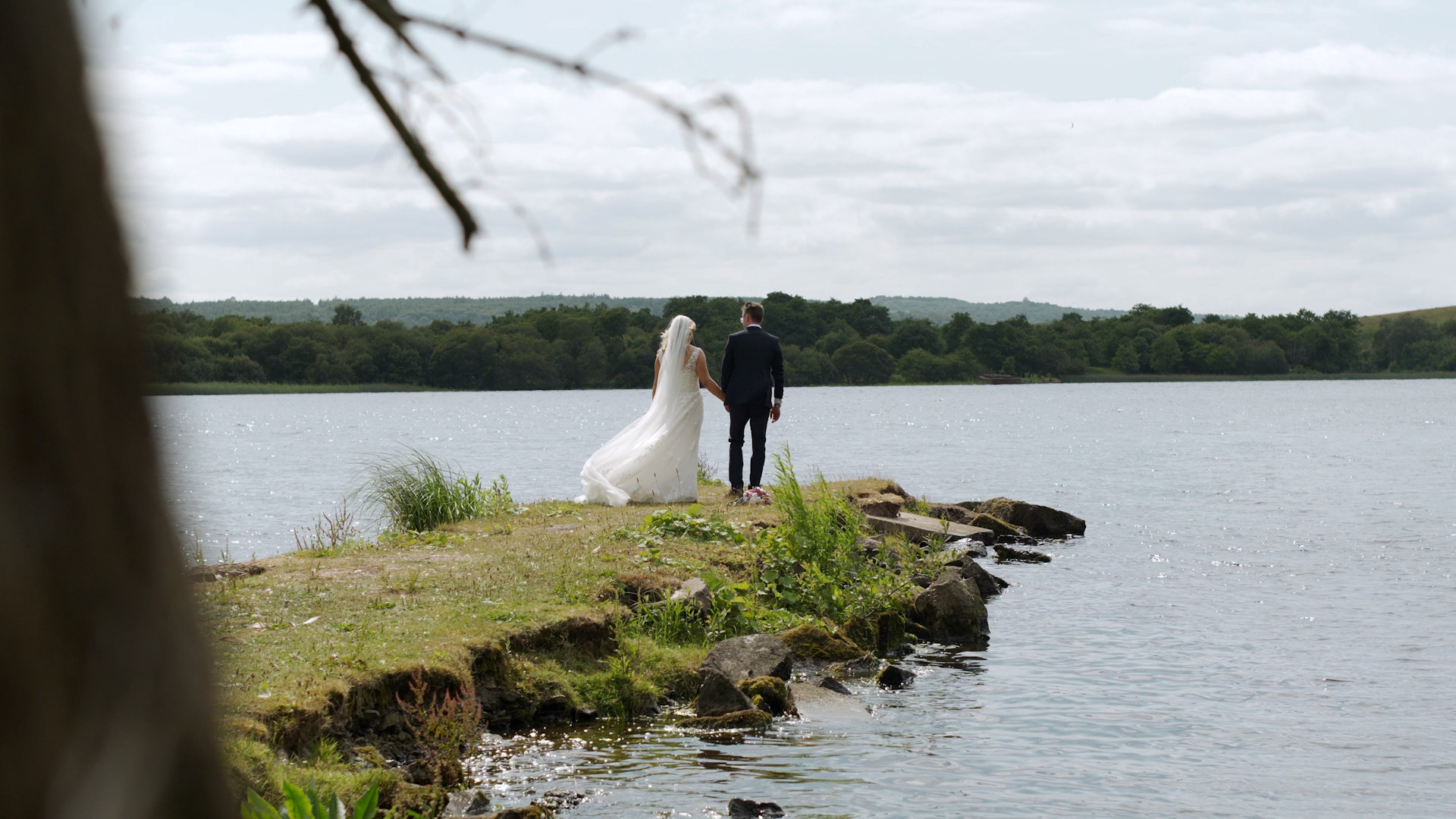 Bride Rachel and groom Scott standing at Lough Erne water's edge at Manor House Hotel